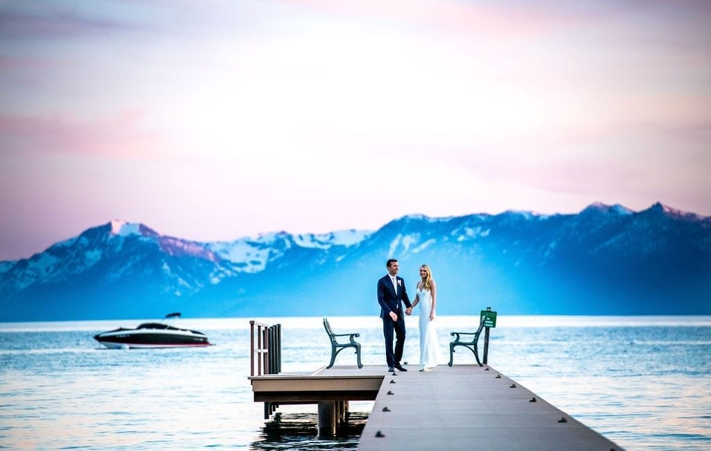 Bride and groom on Lake Tahoe dock with boat in the background